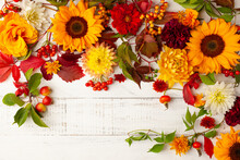 Autumn Composition With Flowers, Leaves And Berries On White Wooden Table. Flat Lay, Copy Space. Concept Of Fall Harvest Or Thanksgiving Day.