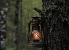 An Old Kerosene Lamp Hangs On A Tree In The Autumn Forest.