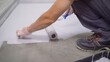 © Ruslan - Contract painter painting garage floor to speed up selling of home. Paint the floor with a roller.