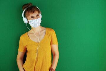 Wall Mural - happy modern learner woman listening to music against green