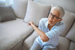 © Dragana Gordic - Elbow Pain In An Elderly Person. People, health care and problem concept - unhappy woman suffering. Senior woman suffering from pain in hand at home. Mature woman suffering from elbow pain at home