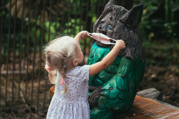 Little girl in medical mask in city park