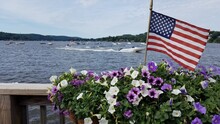 Beautiful Lake And Water Views With An American Flag And Flora In The Foreground; Vacation And Travel Ideas