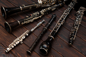 Woodwind instruments lie on a wooden surface. View from above