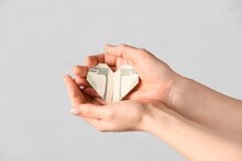 Female Hands With Origami Heart Made Of Dollar Banknote On Light Background