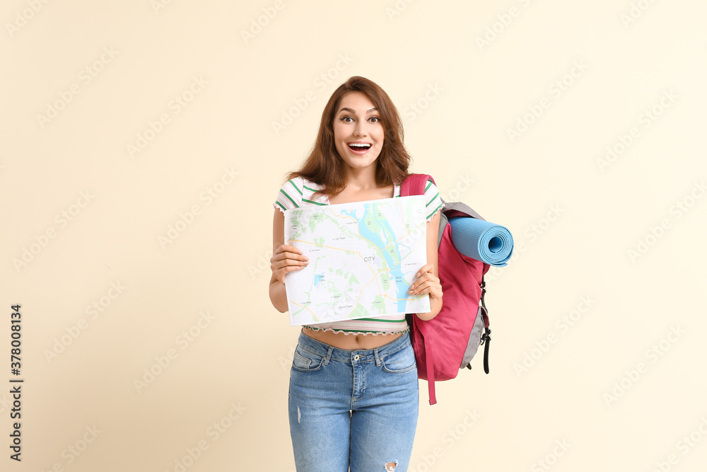 Happy female tourist with map on color background