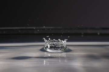 Sticker - Small water drop fall on water surface creating a crown-shaped splash