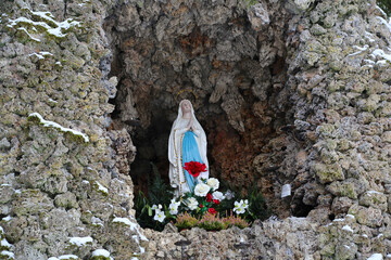 Sticker - Closeup od a small preying place with Jesus statue and flowers