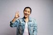 © chajamp - Asian woman happy showing OK sign standing isolated over white background.