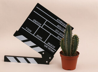 Sticker - Movie clapper board and cactus on beige background. Cinema industry, entertainment