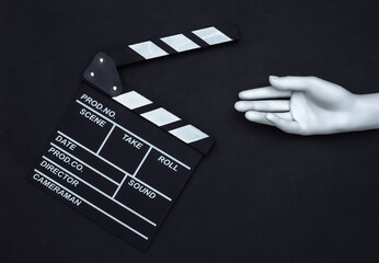 Sticker - Movie clapper board and mannequin hand on black background