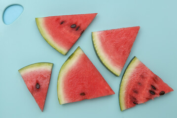 Sliced slices of ripe watermelon on a blue board