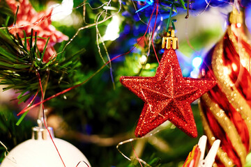 Christmas tree decorated with a vivid red star and other toys. WInter holiday events. Festive backgrounds