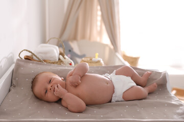 cute little baby on changing table in room