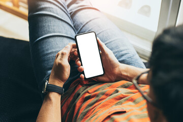 cell phone mockup blank white screen.man hand holding texting using mobile on desk at coffee shop.background empty space for advertise.work people contact marketing business,technology