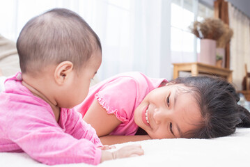 Wall Mural - family with children at home. love, trust and tenderness..little sister hugging her newborn brother. toddler kid meeting new sibling. cute girl and new born baby boy relax in a white bedroom.