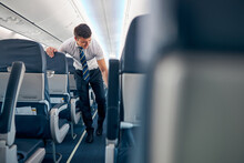 Confident Male Working On The Empty Salon Of Passenger Airplane