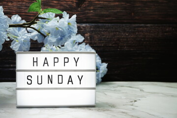 Wall Mural - happy sunday word in light box with flowers decoration