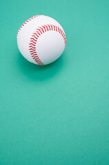 Canvas Print - Vertical shot of a baseball ball isolated on turquoise background