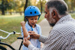 © cherryandbees - grandfather puts band aid on arm to his grandson