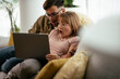 © JustLife - Young couple watching movie on lap top. Loving couple enjoying at home....