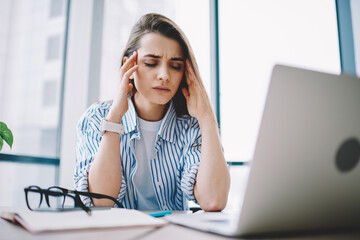 Wall Mural - stressed female freelancer tired from bad internet connection sitting at office desktop with netbook