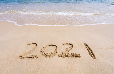 Wall Mural - 2021 year message handwritten in sand on beautiful beach background. New Years concept.