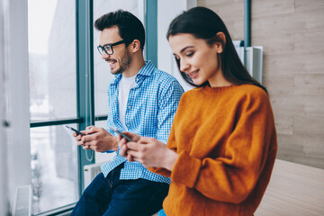 Wall Mural - caucasian millennials using modern cellphones for sharing media files via bluetooth connection, male