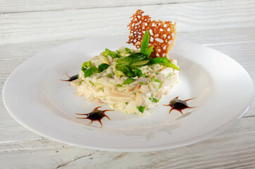 summer vegetable salad on a white dish on a wooden background