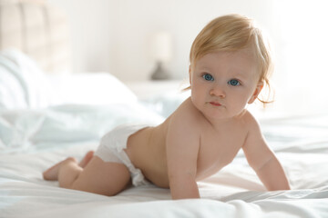 Sticker - Cute little baby in diaper on bed at home