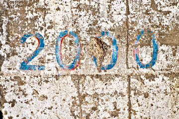 Number 2000, two thousand, in blue stencil digits on a weathered white wall.