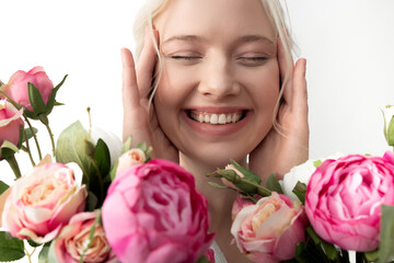 Wall Mural - Cheerful young woman with flowers touching her face