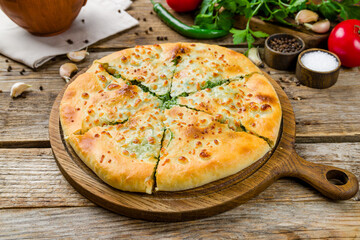 Wall Mural - khachapuri with spinach on old wooden table, georgian kitchen