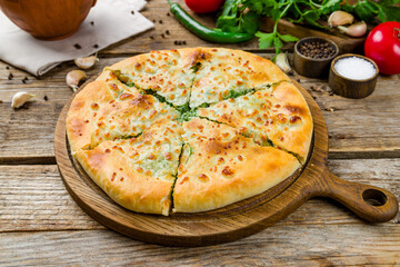 Poster - khachapuri with spinach on old wooden table, georgian kitchen