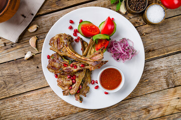 Wall Mural - kebab from a rack of lamb with tomato sause on white plate on old wooden table top view