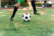 © gorynvd - Soccer player kicking ball on field. Soccer players on training session. Close up footballer feet kicking ball on grass.
