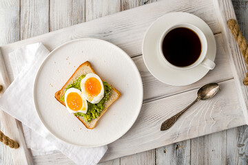 Wall Mural - Toast with guacamole and boiled egg, avocado toast with coffee cup