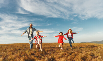 Wall Mural - Happy family: mother, father, children son and daughter on sunset.