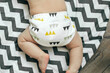 © Anikonaann - Baby boy in Eco cloth diaper on children's rug. Zero waste, eco-friendly concept. Top view