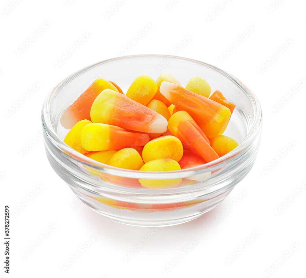 Bowl with tasty candies for Halloween on white background