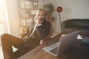 Wall Mural - Portrait of his he nice attractive classy stylish cheery guy ceo boss chief economist finance agent broker sitting in chair deciding employment drinking latte at workplace workstation