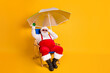 © deagreez - Full size photo of white grey hair bearded santa claus sit chaise-lounge raise alcohol glass x-mas christmas eve noel time relax wear hat pants isolated bright shine color background