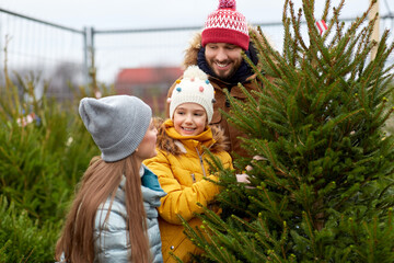 Sticker - family, winter holidays and people concept - happy mother, father and little daughter choosing christmas tree at street market