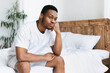 © Prostock-studio - Unhappy Black Guy Sitting On Bed In Bedroom At Home