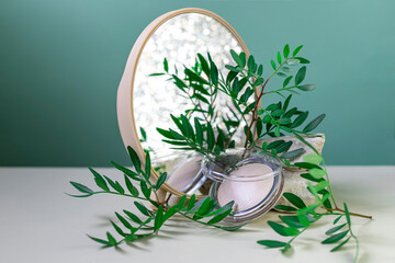 Mineral powder on a green background. Modern still life with copy space.