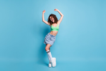 Wall Mural - Full size photo of carefree crazy lady model scream loud music hands air party clubber hang out youngster activities advert wear green top jeans skirt isolated pastel blue color background