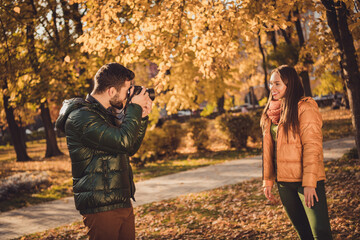 Poster - Photo of professional photographer guy take photo of beautiful girl posing in fall october town park