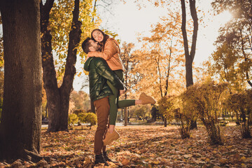 Sticker - Full body photo of passionate couple guy hold his girlfriend stand in fall town forest park wear coats