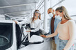 © fotofabrika - Woman car dealer consulting buyers wearing medical face shield