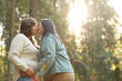 © AnnaStills - Two overweight lesbians kissing each other during their walk in the forest